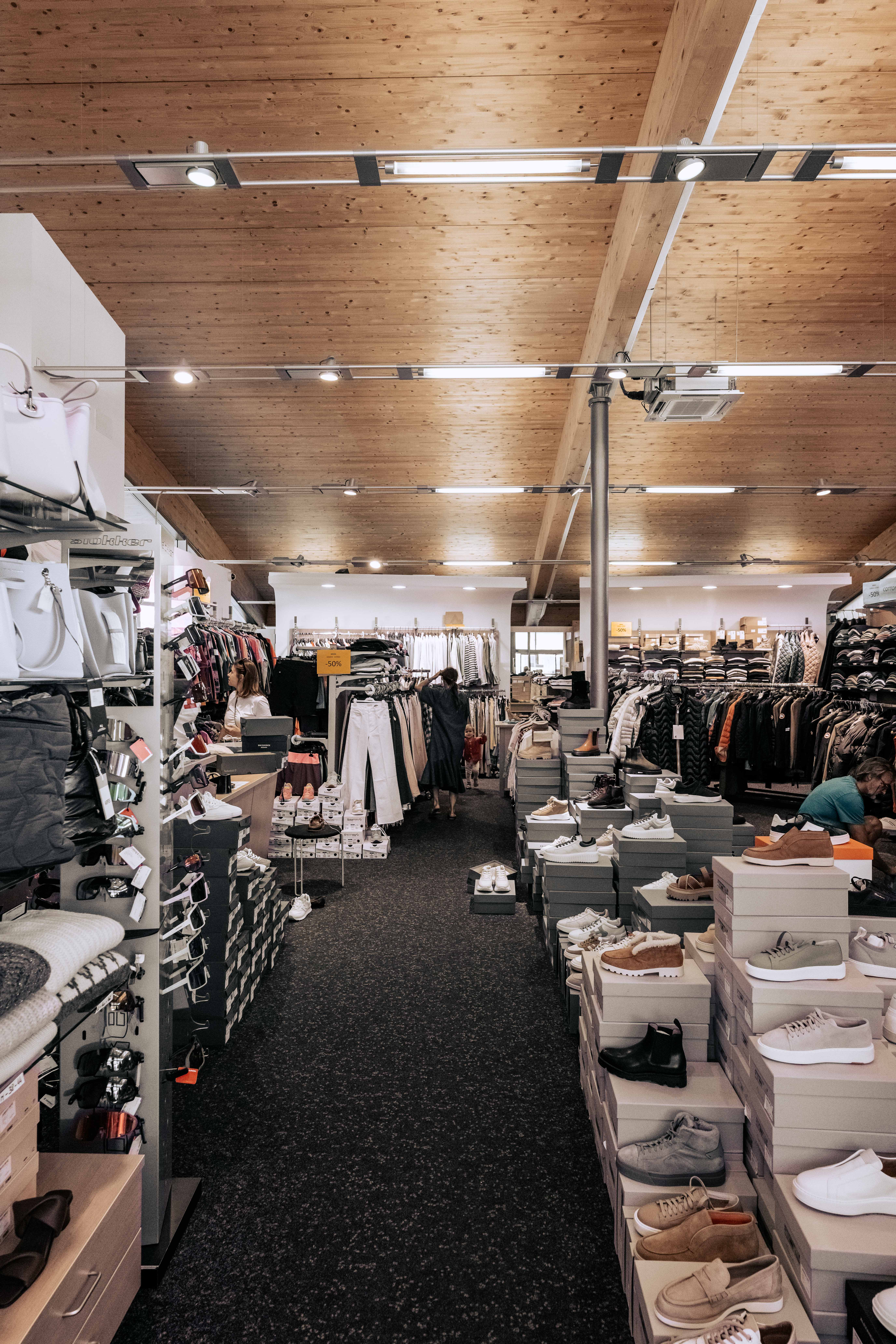 Verkaufsraum des Fashion Outlet mit Bekleidung und Taschen