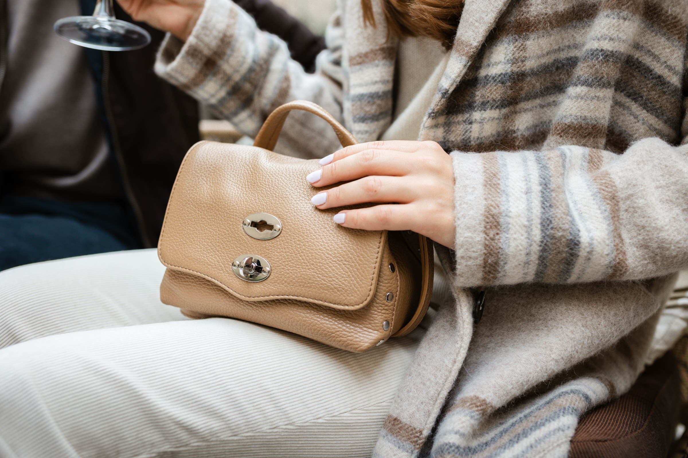 Beige Handtasche zu einem karierten Mantel