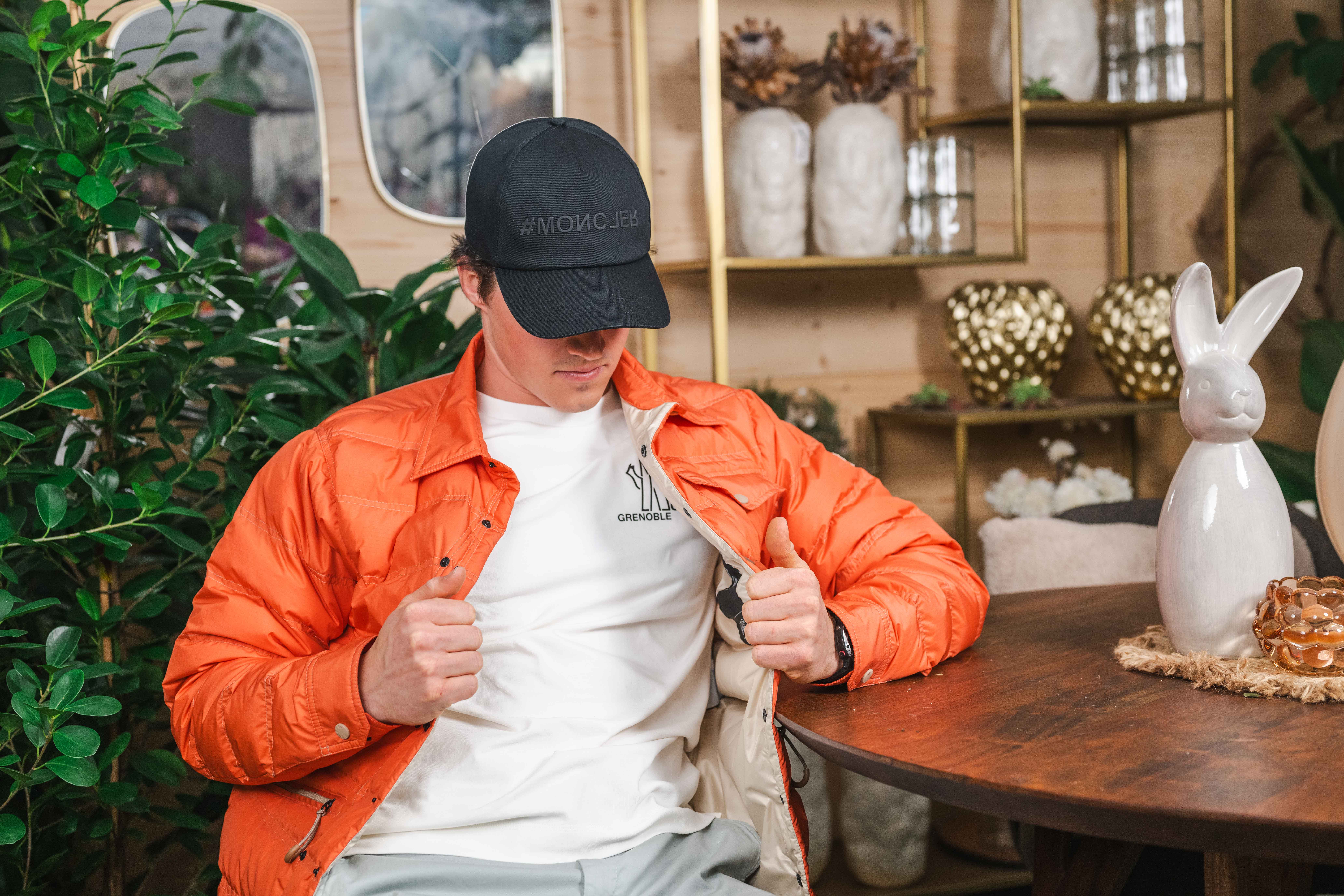Mann mit orangefarbener Jacke und dunkler Kappe