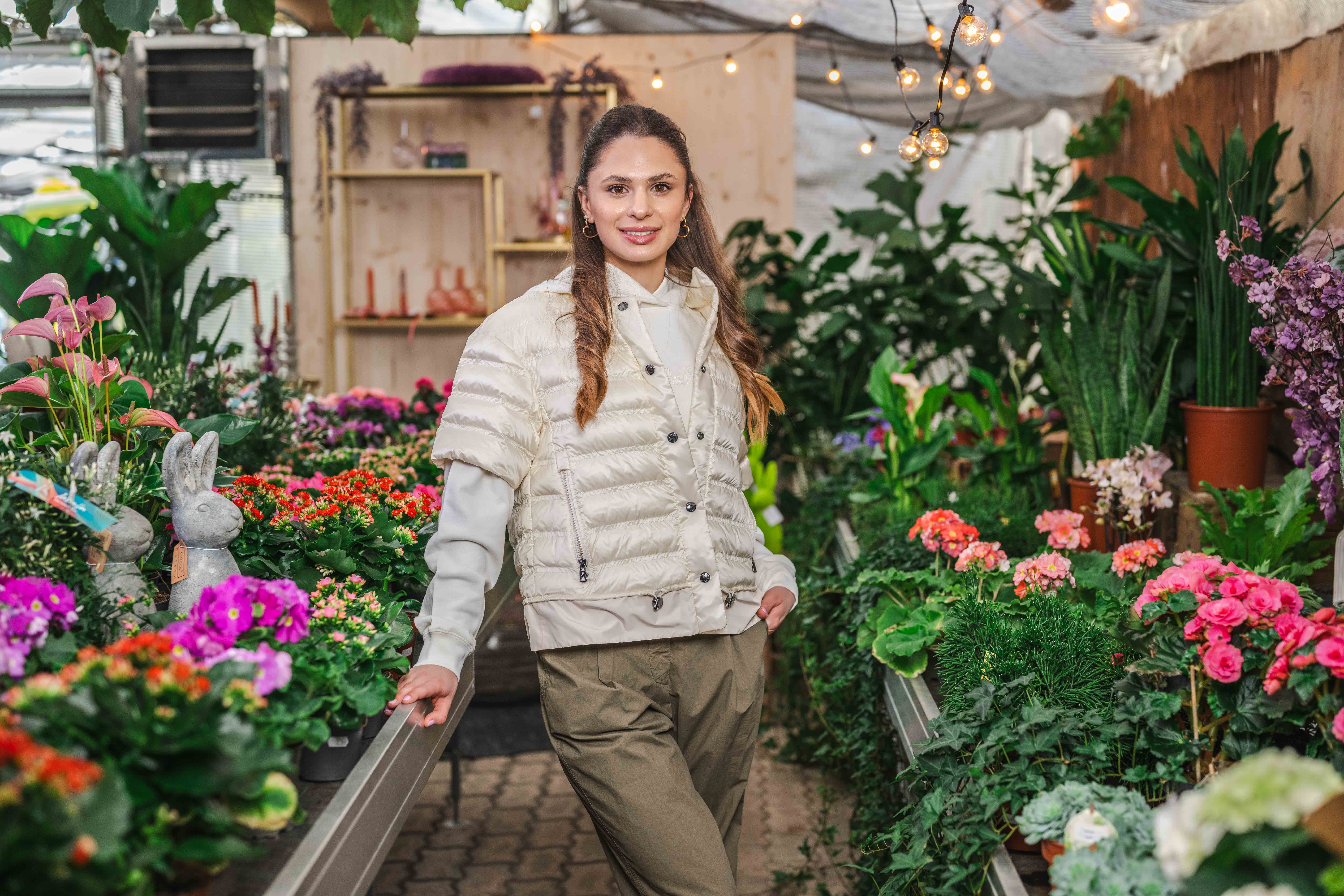 Frau mit heller Jacke vor einem Blumenladen